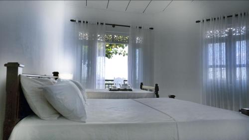 卡卢特勒Ananthaya -the infinity的白色的卧室设有床和窗户