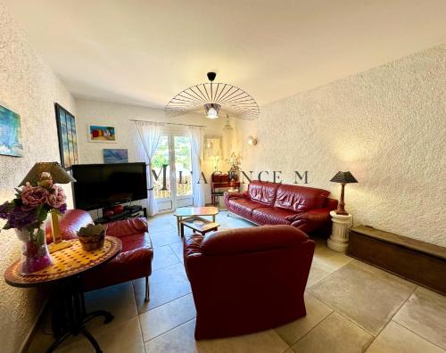 阿尔加约拉Maison de village typique bord de mer的客厅配有红色皮革沙发和电视