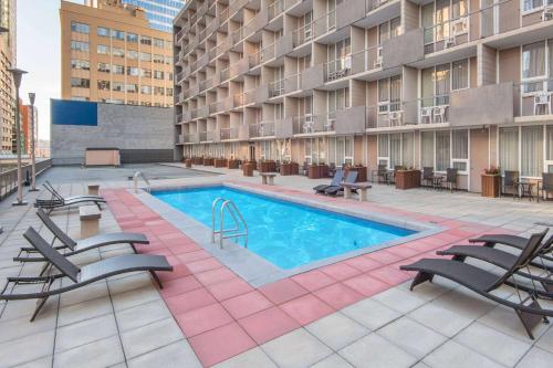 卡尔加里卡尔加里市中心华美达酒店的一个带游泳池和椅子的公寓庭院