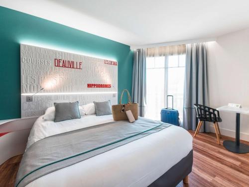 多维尔多维尔市中心宜必思尚品酒店的一间卧室配有一张大床和一张书桌