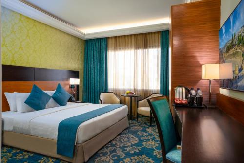 安曼安曼公司酒店的酒店客房配有一张床铺和一张桌子。