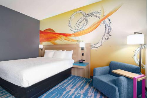 圣安东尼奥La Quinta Inn & Suites by Wyndham San Antonio Seaworld LAFB的一间卧室配有一张床和一张蓝色椅子