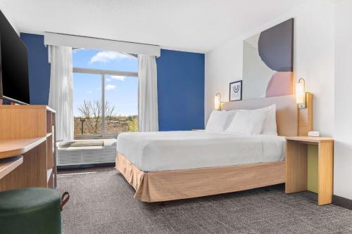 夏洛特 夏洛特机场南I-77提渥拉温德姆集团温盖特酒店的一间卧室设有一张大床和一个窗户。