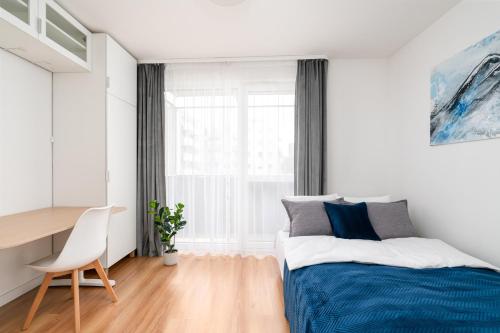 弗罗茨瓦夫Crystal Apartment的一间卧室配有一张床、一张书桌和一个窗户。