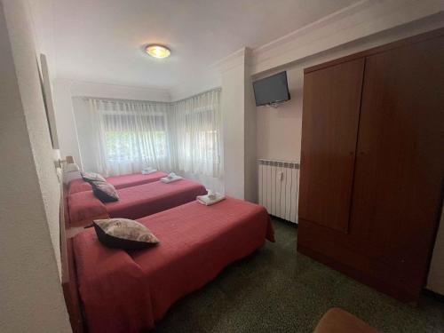 萨拉戈萨康伯利旅馆的酒店客房设有两张床和电视。