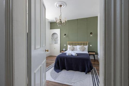 格拉斯哥Spacious 3 Bedroom Home In Glasgow - Free Parking的一间卧室配有一张带蓝毯和吊灯的床。