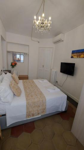 都灵Casamassena的卧室配有一张白色大床和吊灯。