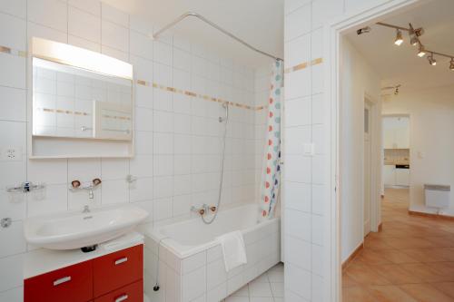 布里萨戈Brissago Lake Apartment的白色的浴室设有浴缸和水槽。