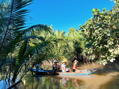 Ấp Phú Hòa (3)Hide Away Bungalows in Ben Tre City的一群人乘着一条河上的小船