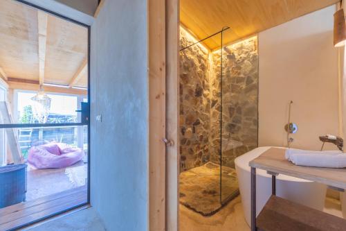 塔里法Casa CORTIJO con piscina privada的带浴缸和玻璃淋浴间的浴室。