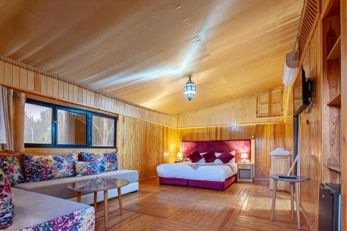 马拉喀什Ferme Sidi Safou & Spa的一间卧室配有一张床和一张沙发