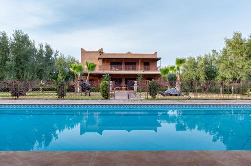 马拉喀什Ferme Sidi Safou & Spa的房屋前有游泳池的房子