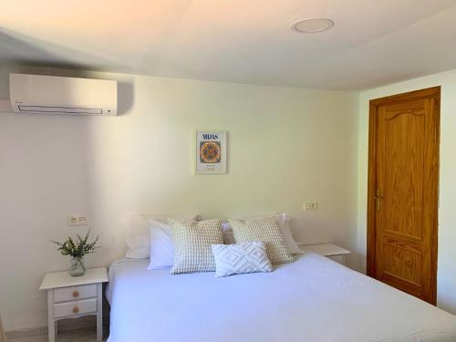 Las Lagunas MijasSpanish charm guest apartment at villa with great location!的卧室配有白色的床和木门