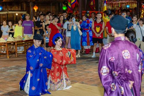 富国Legacy Phú Quốc的一群穿着传统服装的人在人群中行走