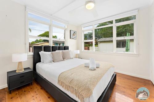 悉尼Aircabin - North Ryde - Sydney - 4 Beds House的一间卧室设有一张大床和两个窗户。