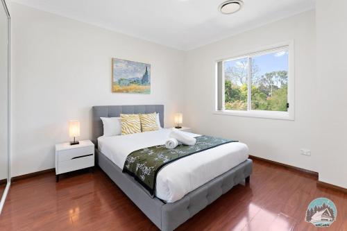 PananiaAircabin - Panania - Sydney - Cozy - 5 Beds House的一间卧室设有一张大床和一个窗户。