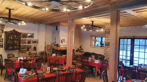 KaplavaZirgu sēta "Klajumi" - Horse ranch "Klajumi"的一间设有红色桌椅和天花板的用餐室
