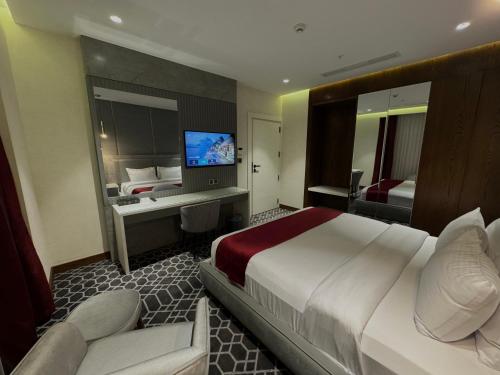 埃尔比勒Ankawa Holiday Hotel的酒店客房设有一张大床和一台电视。