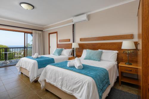 Elysium糖海滩度假酒店的带阳台的酒店客房内的两张床