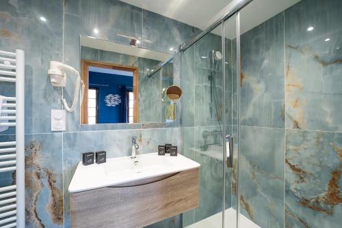 佩皮尼昂Suites Coronell d'En Vila的一间带水槽和玻璃淋浴的浴室