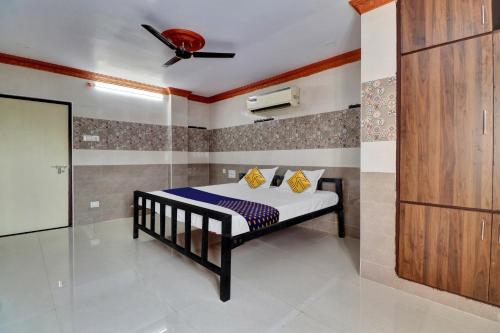 OngoleSPOT ON Hotel Maha Lakshmi的一间卧室配有一张带吊扇的床