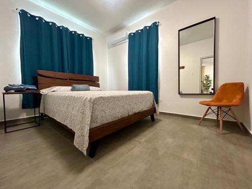 多拉多Dorado Beach House的一间卧室配有一张带蓝色窗帘和镜子的床
