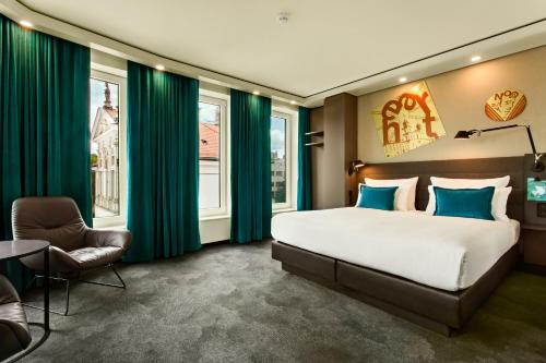 华沙Motel One Warsaw-Chopin的一间卧室配有大床和绿色窗帘