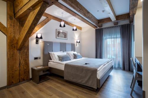 克莱佩达麦克尔森精品酒店的一间带一张大床的卧室,位于一个拥有木制天花板的房间