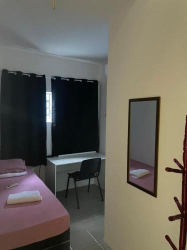 维拉可波斯Pousada Aeroporto Viracopos Campinas的客房设有一张床、一张书桌和一面镜子