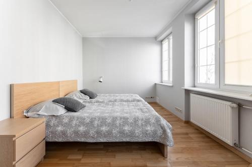 格但斯克Apartament Świętego Ducha 3234的一间卧室设有一张床和两个窗户。