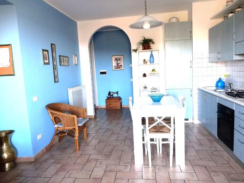 San Savino博尔戈圣洛伦萨维诺公寓的厨房拥有蓝色的墙壁和白色的桌椅