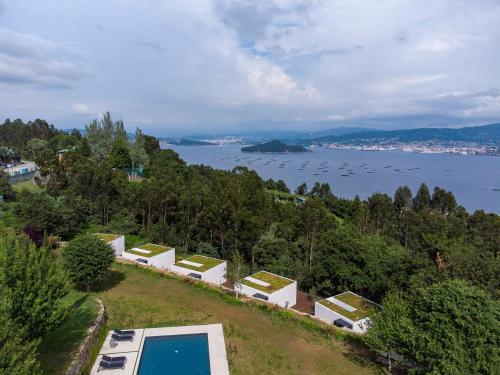 拉科萨Hotel Pepe Vieira Relais & Châteaux的水边小山上带游泳池的房子