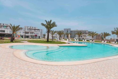 帕拉卡斯PARADISUS PARACAS Gran Casa de Playa con Jacuzzi!的棕榈树和建筑度假村内的游泳池