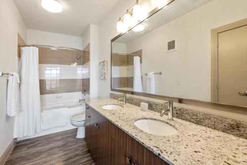 欧文Landing at City North - 1 Bedroom in Valley Ranch的浴室设有2个水槽、卫生间和镜子。