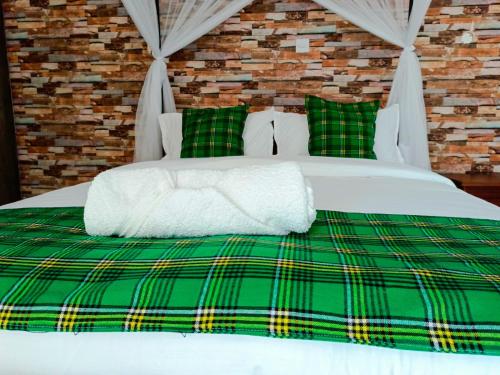 基苏木Queen's Way Resort的一张带绿色和白色毯子及枕头的床