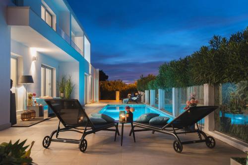 普拉Monvidal Residence - Adults Only的一个带两把椅子的庭院和一个游泳池
