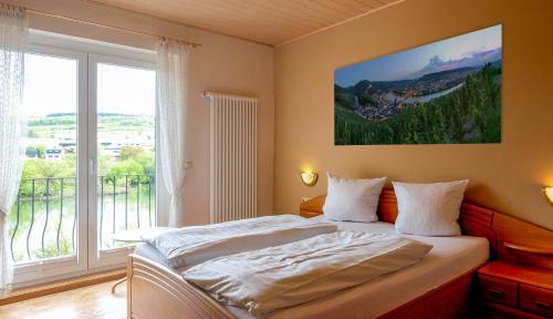 于尔齐希盖拉赫葡萄酒庄/酒店的一间卧室设有一张床和一个大窗户