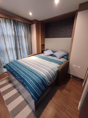 盖尔文Luxury Pods at Mornest Caravan Park, Anglesey的一间卧室配有一张带蓝色床单的床和一扇窗户。