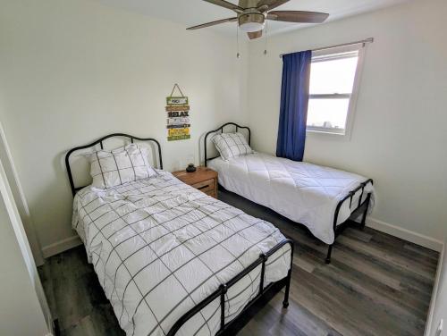 LanarkNewly Renovated 2 Bedroom Beach Front Condo 2C的一间卧室配有两张床和吊扇