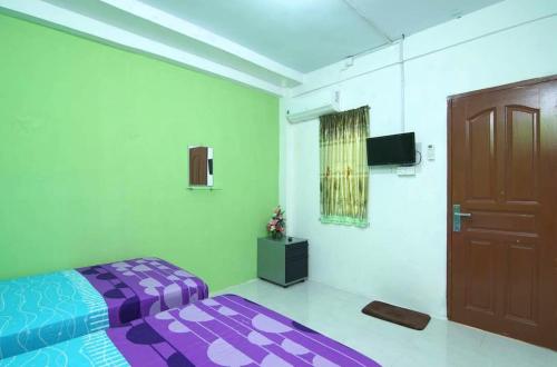 秾莎BOTANIA HOMESTAY BATAM的一间卧室设有紫色的床和门