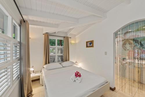 威廉斯塔德Villa Papaya的白色的卧室设有床和窗户