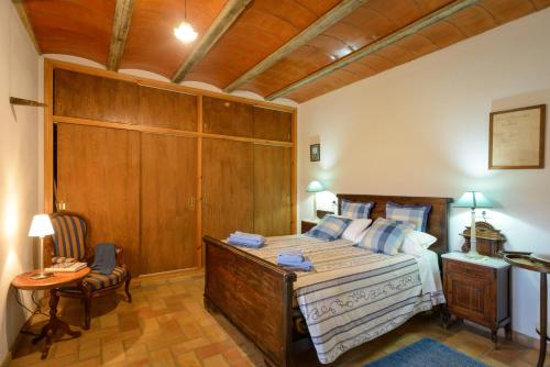 AiguavivaCan Guinau的一间卧室设有一张大床和木制天花板