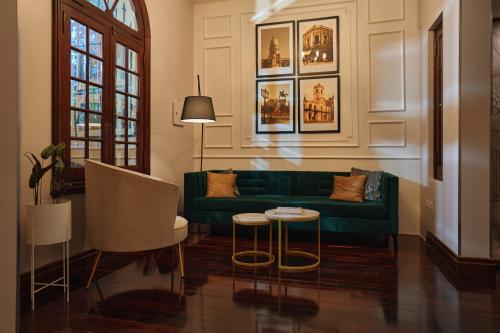 布宜诺斯艾利斯摩拉维亚苏豪酒店的客厅配有绿色沙发和桌子