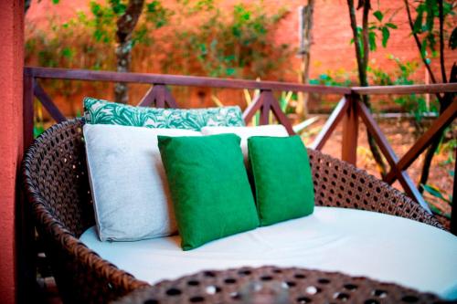皮雷诺波利斯Ananda Pousada的配有4个绿色和白色枕头的藤椅