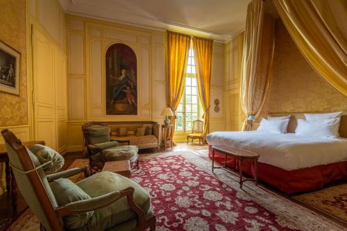 埃托日Le Château D'Etoges的一间卧室配有床、椅子和窗户
