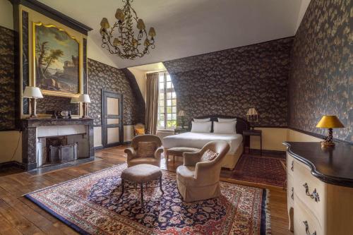 埃托日Le Château D'Etoges的一间卧室配有一张床和一个壁炉