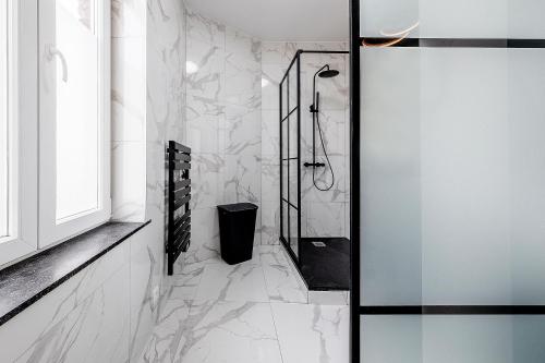 列日Marshmallow的一间设有白色大理石墙壁和淋浴的浴室