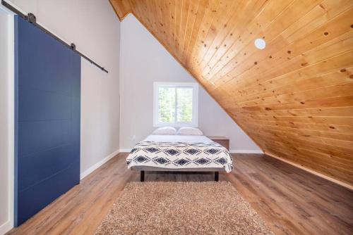 Fort CoulongeRiverside Retreat: Maazah Cottage的一间卧室设有一张床和木制天花板