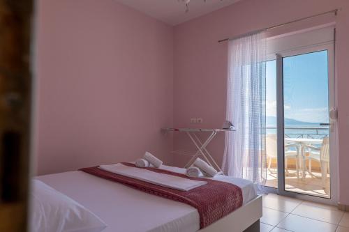 萨兰达Noel Sea View Apartments的一间卧室设有一张床,享有海景