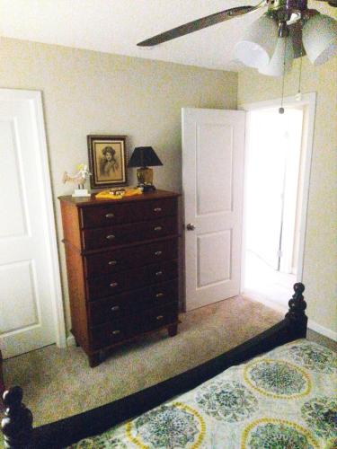 圣奥古斯丁DANA ESTATE's的一间卧室配有一张床、一个梳妆台和一扇窗户。